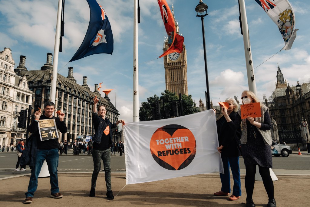 Campaigners with banner in front of Houses of Parliament