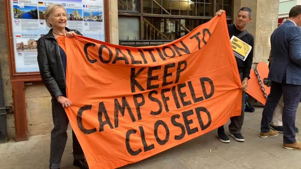 Protesters in Oxford city centre with large banner reading "Coalition to Keep Campsfield Closed"