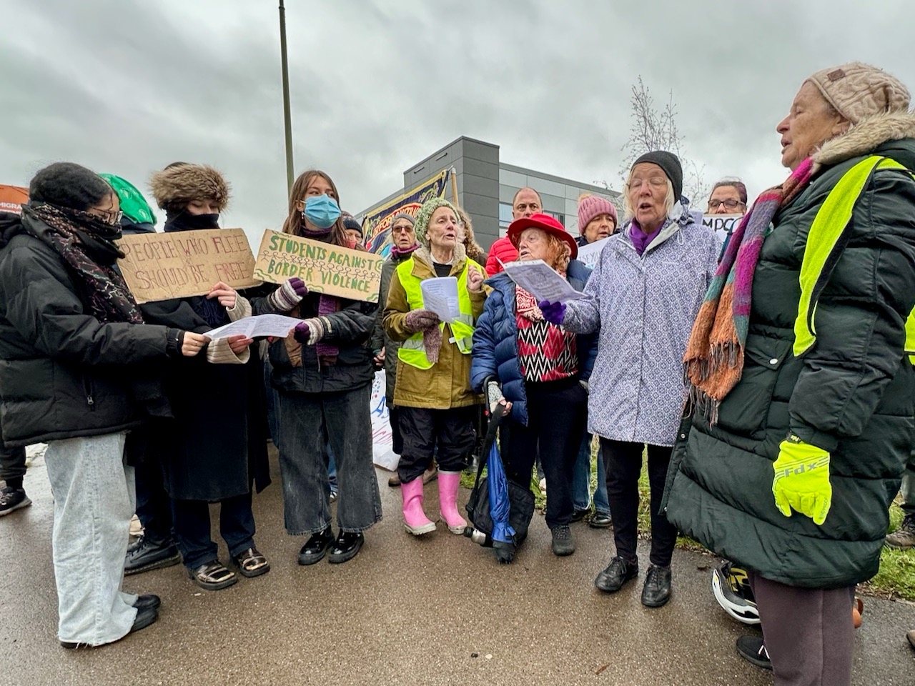 Video clip of The Sea Green Singers lead a song of solidarity and resistance at the protest outside Campsfield House