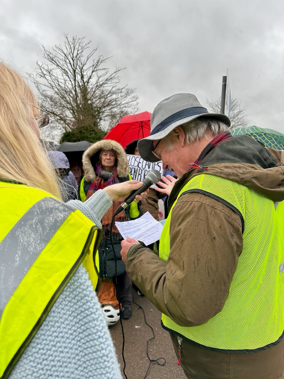 Bill MacKeith reads a supportive message from Calum Miller Liberal Democrat MP for Bicester & Woodstock constituency, to protesters outside Campsfield House