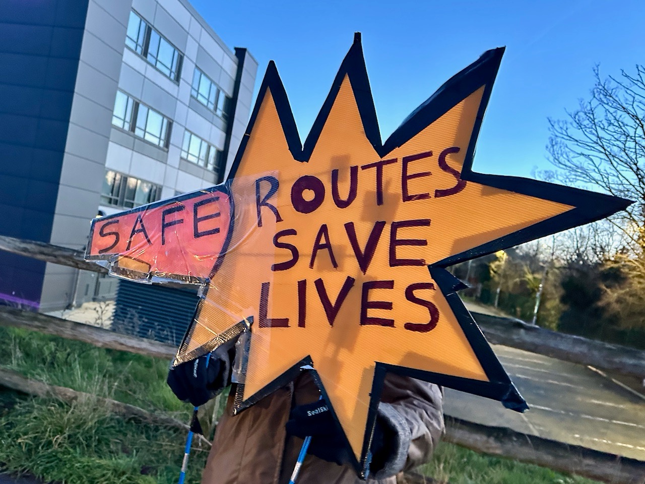 Placard reading "Safe routes save lives"