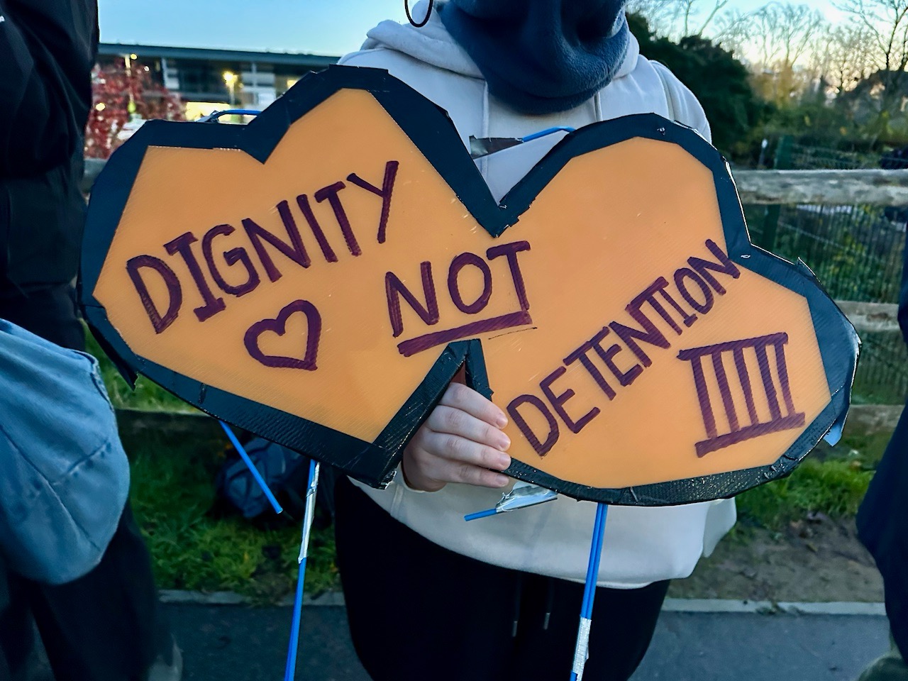 Placard reading "Dignity not detention"