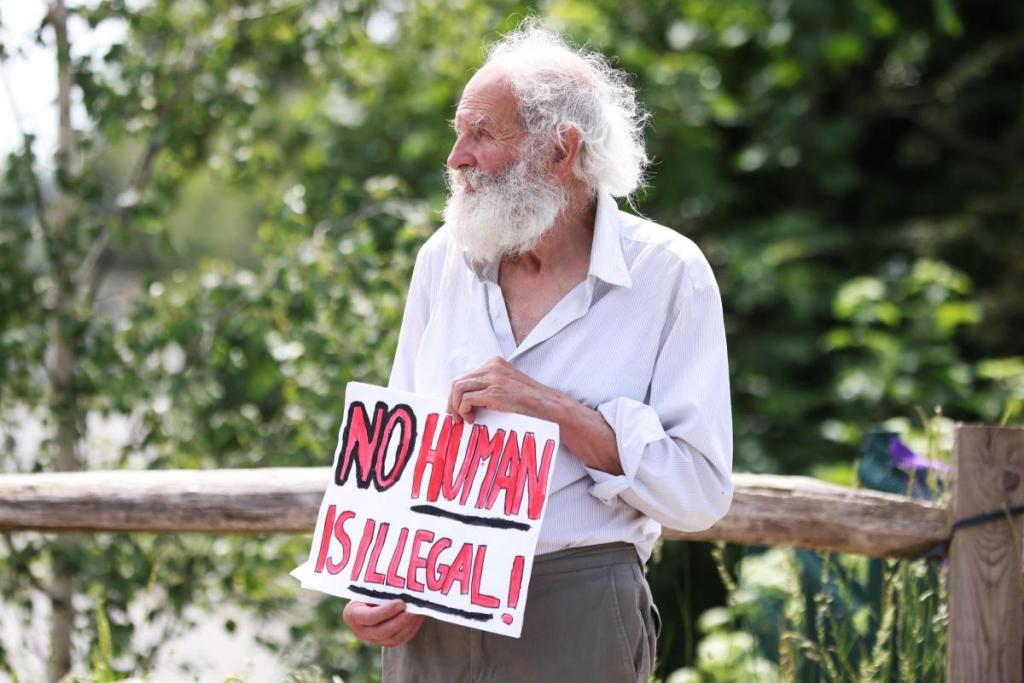 A protestor holds a placard reading "No human is illegal" near the entrance to Campsfield House IRC in Kidlington, in a protest over 'slave labour' wages paid to its detainees (Photo: Ed Nix)