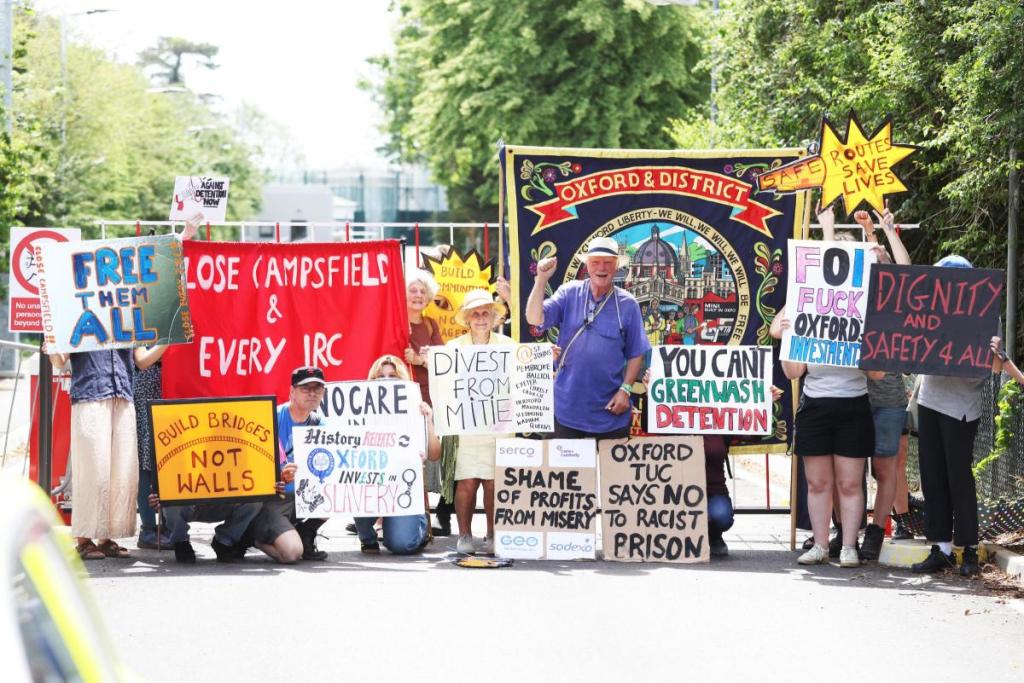 Around 20 protestors, with placards and banners, including the Oxford & District Trades Union Council banner, near the entrance to Campsfield House IRC in Kidlington, protesting over 'slave labour' wages paid to its detainees (Photo: Ed Nix)