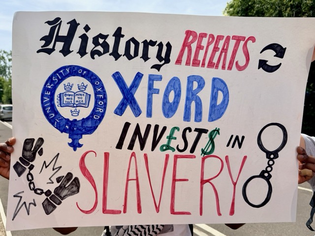 Placard reading "History repeats: Oxford invests in slavery"