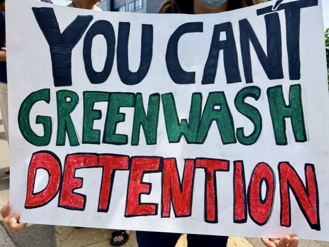 Placard reading "You can't greenwash detention"