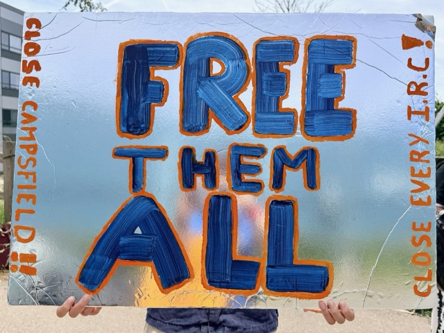 Placard reading "Free them all"
