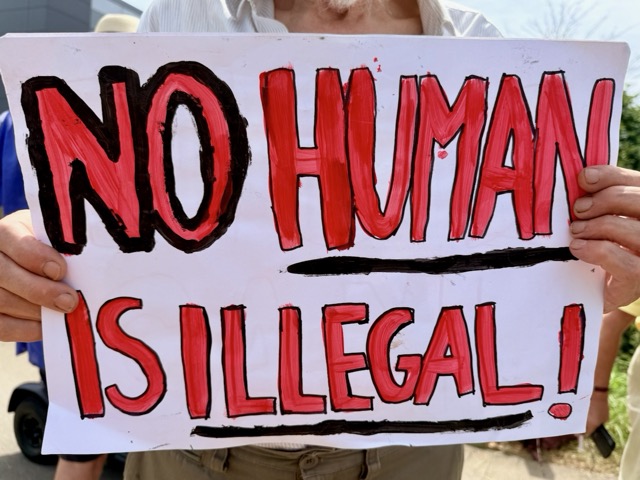 Placard reading "No human is illegal"