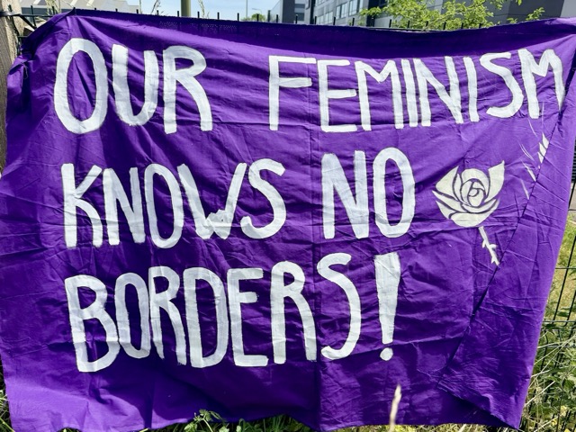 Banner reading "Our feminism knows no borders!"